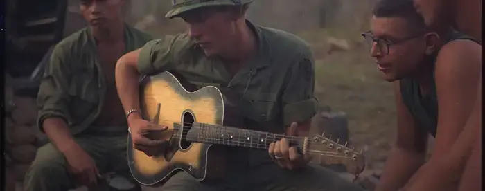 Members of Company "A," 3rd Battalion, 22nd Infantry (Mechanized), 25th Infantry Division, gather around a guitar player and sing a few songs.
