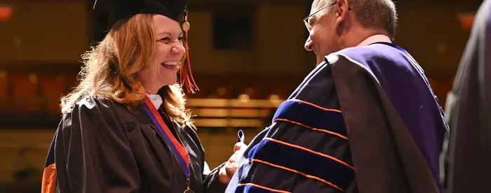 Image of an MA graduate accepting their diploma