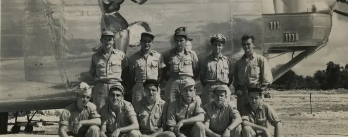 A photograph of Robert L. Stone's crew posed in front of one of the B-24 Liberators they flew.