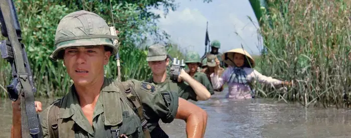 American soldiers wade through a canal in Vietnam