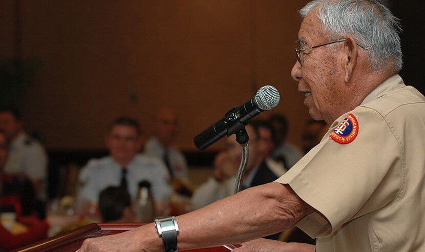 Photograph of Joe Morris Sr. giving a talk at a lectern displaying the NASA logo.