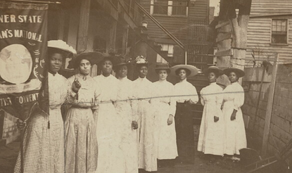 Nannie Helen Burroughs holding banner. African-American women posed, standing, full length, with Nannie Burroughs holding banner reading, "Banner State Woman's National Baptist Convention."
