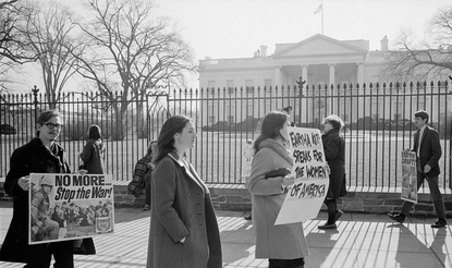A photograph of anti-Vietnam War demonstrators carrying signs, "No more...Stop the war!", "Eartha Kitt speaks for the women of America", and "Stop the draft", picketing in front of the White House.