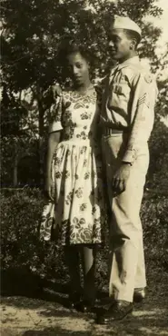 Black and white photograph showing a soldier in a military uniform with his arm around a woman.