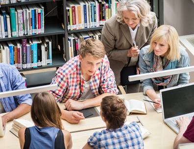 teacher guides students at a library