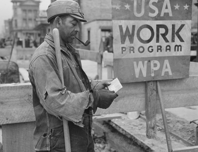 Photo showing WPA worker receiving a paycheck with sign in background "USA Work Program WPA"