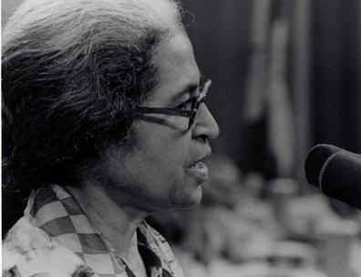 Rosa Parks speaking at a microphone