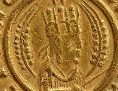 Obverse of coin with half-length bust of Ezanas right, crowned, holding a stick or scepter, flanked by two wheat-stalks, the whole in a beaded circle with Greek lettering around the outside.