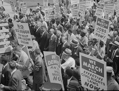 Photograph of civil rights leaders, including Martin Luther King, Jr., surrounded by crowds carrying signs.