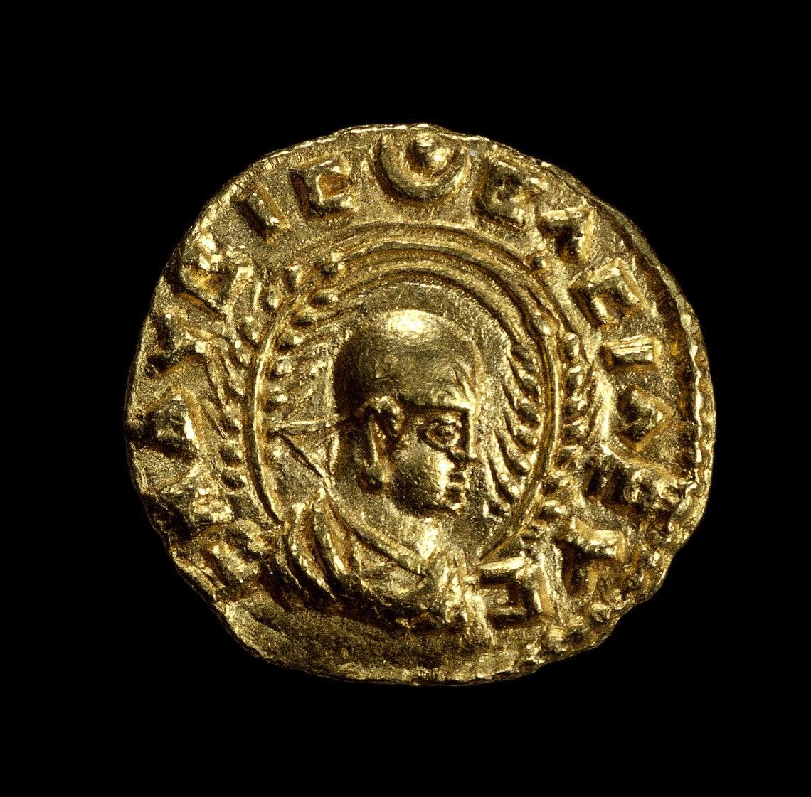Obverse of coin with half-length bust of Ezanas right, crowned, holding stick or scepter, flanked by two wheat stalks, and Greek letters around the outside, the whole in a beaded circle