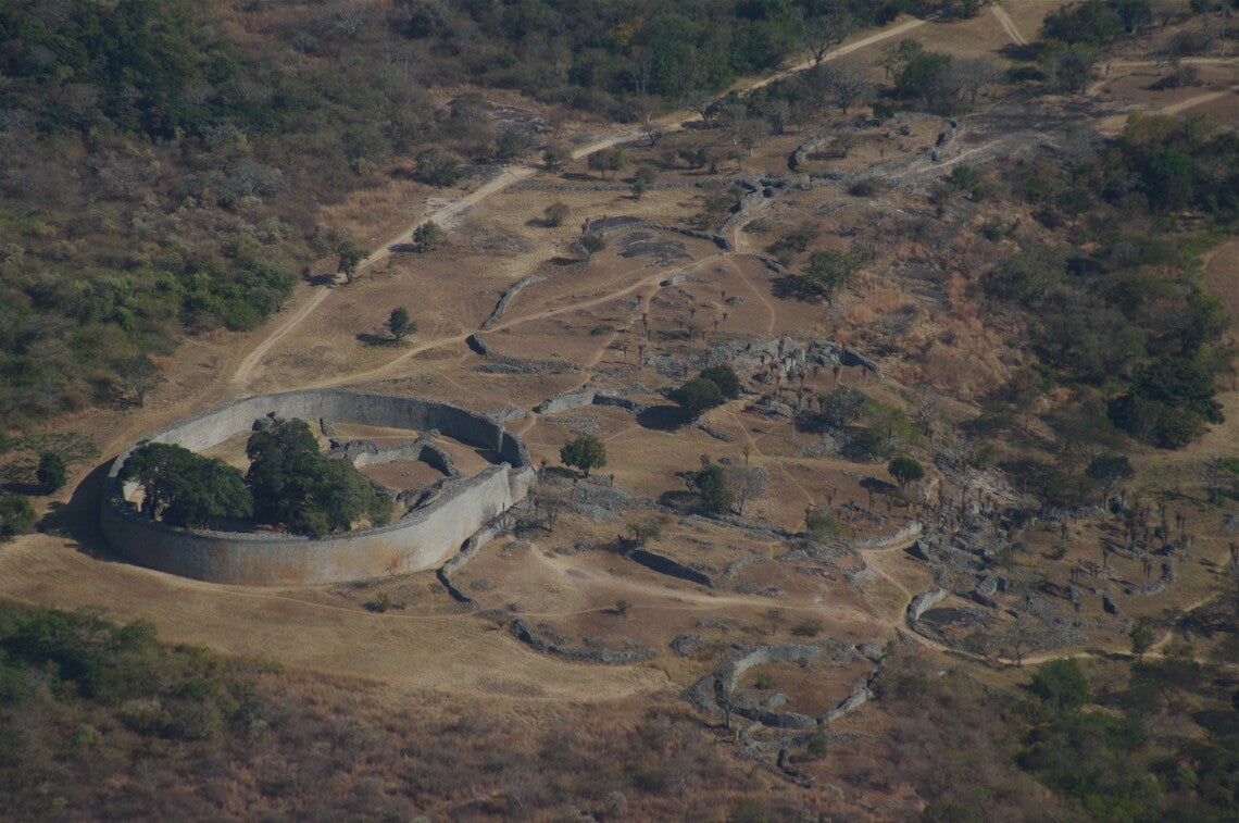 An overhead view of a round stone structure (at left) with stone ruins (at right)