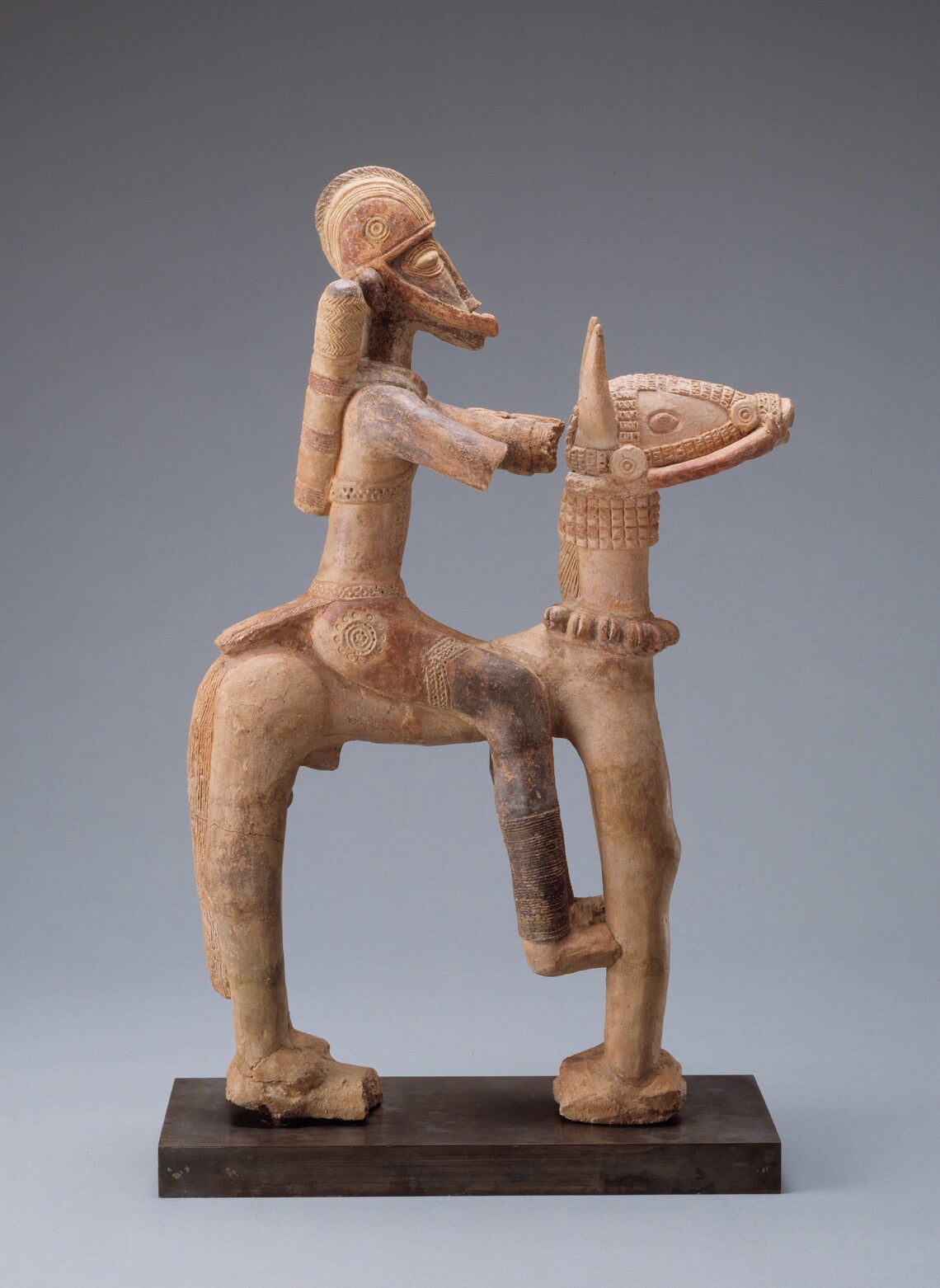 Stylized clay sculpture of an armored soldier on a horse.