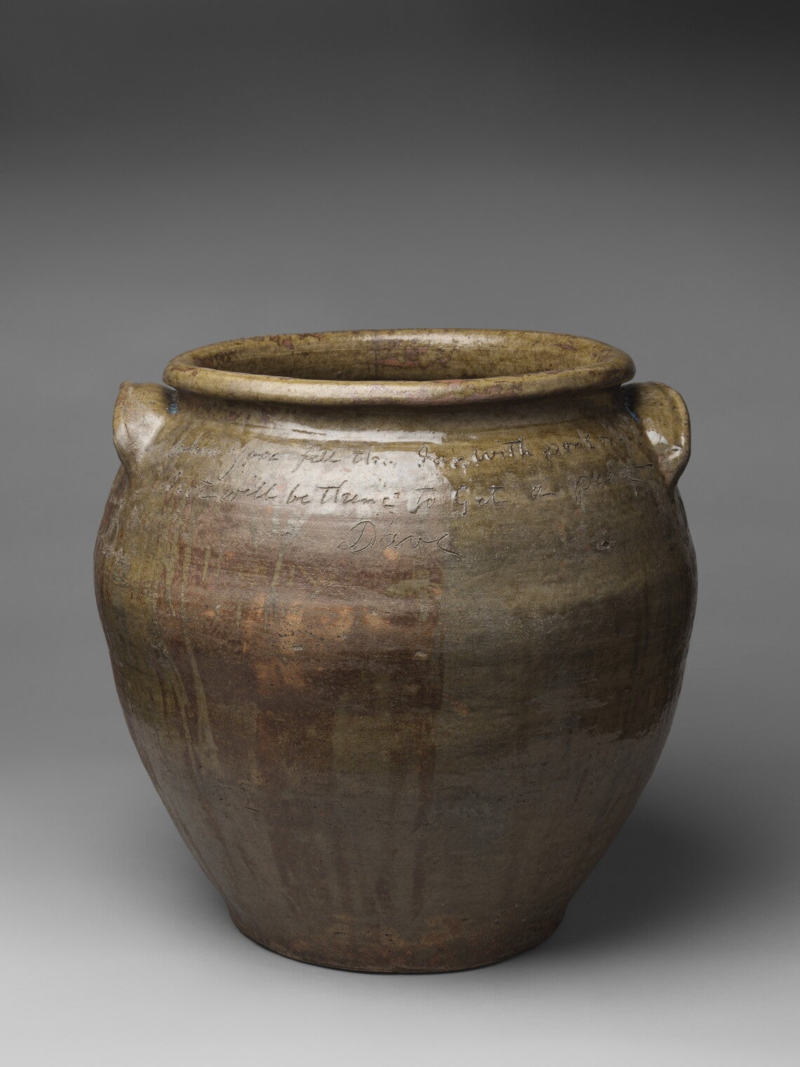 A wide-mouthed brown earthenware jar with two handles and writing inscribed on the surface