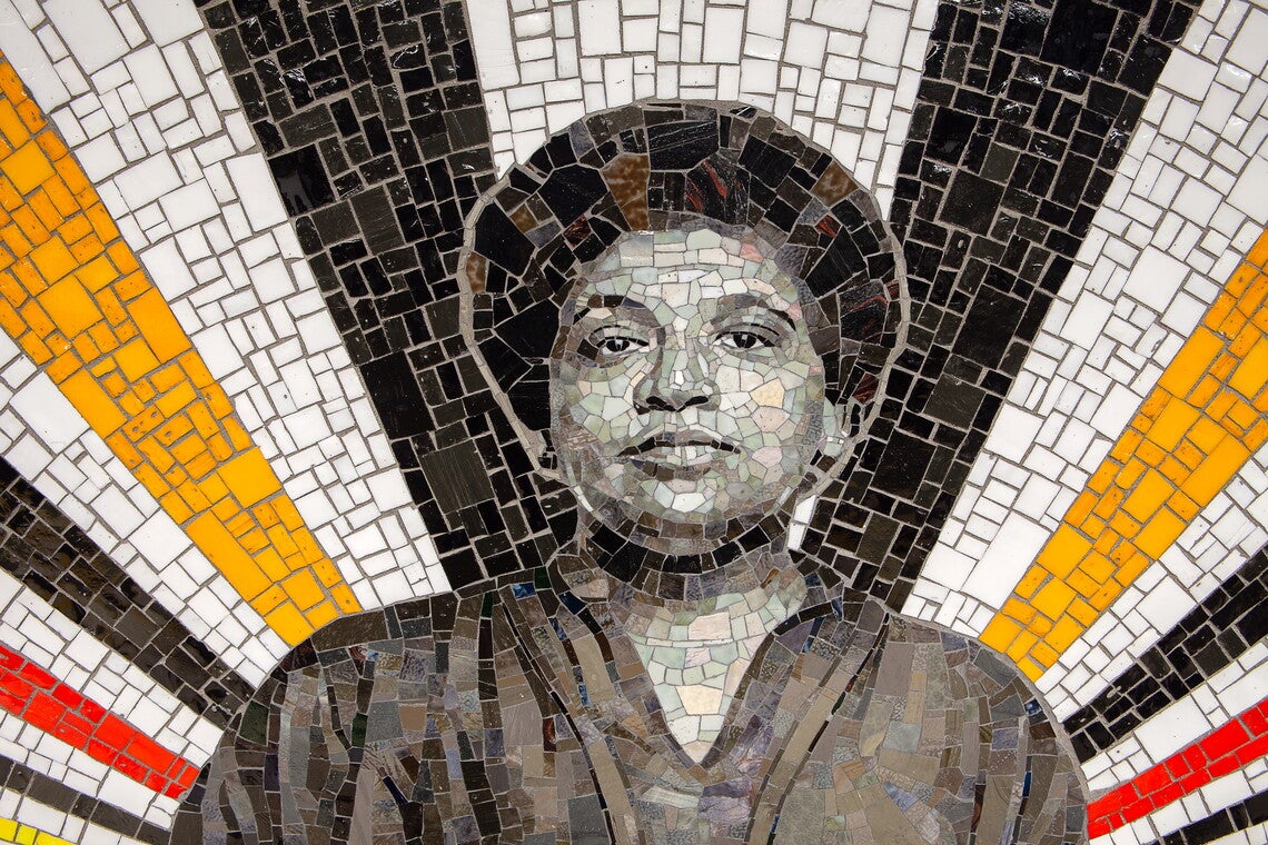 A mosaic featuring a black and white portrait of Audre Lorde surrounded by bursts of gold, white, and black tiles.