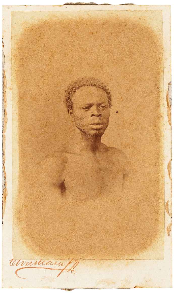 A sepia portrait of a Black man bearing ceremonial scars.