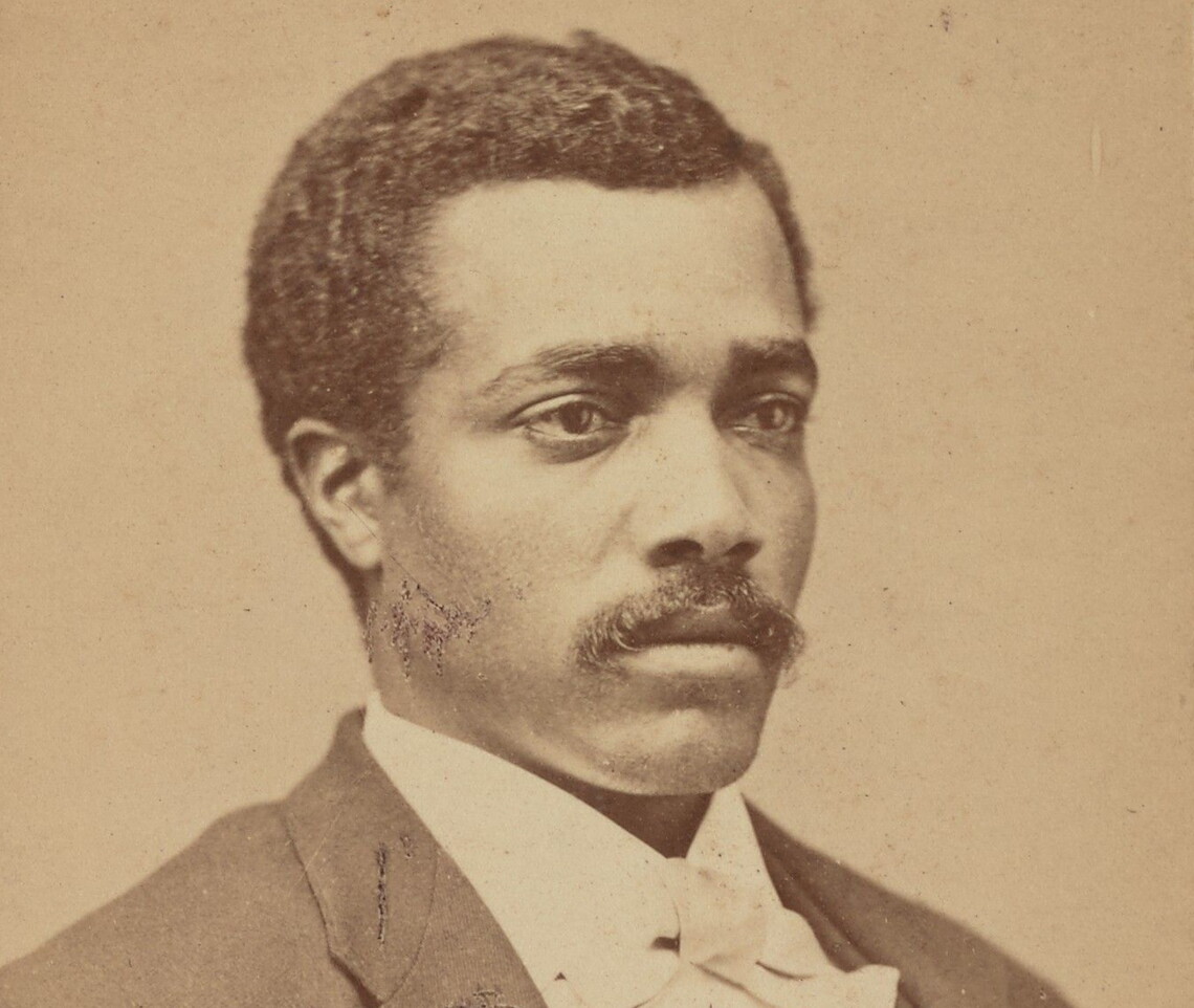 Josiah Thomas Walls, a mustachioed Black man, in three-quarter profile wearing a dark jacket and vest and white shirt and bow tie.